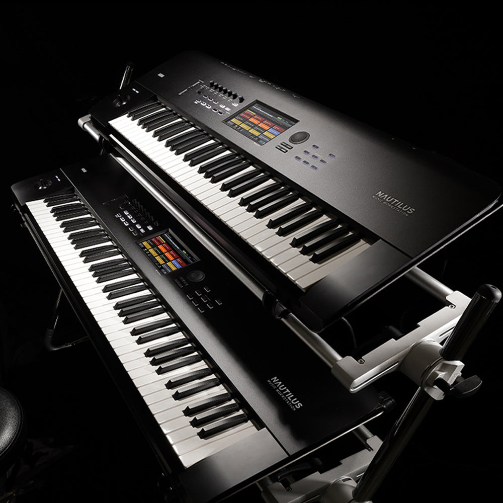 two stacked KORG keyboard workstations with dramatic lighting in a dark studio