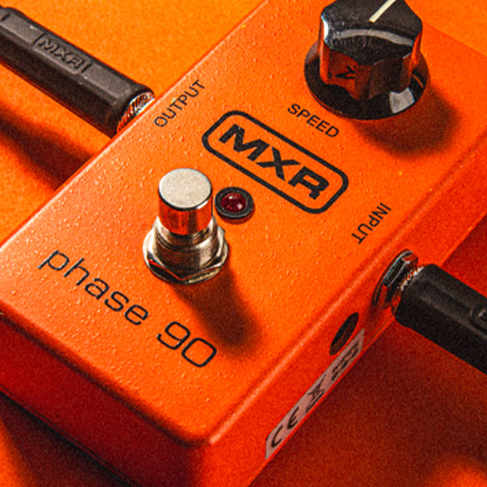 Orange MXR phase 90 effects pedal with black accents resting on a matching orange surface