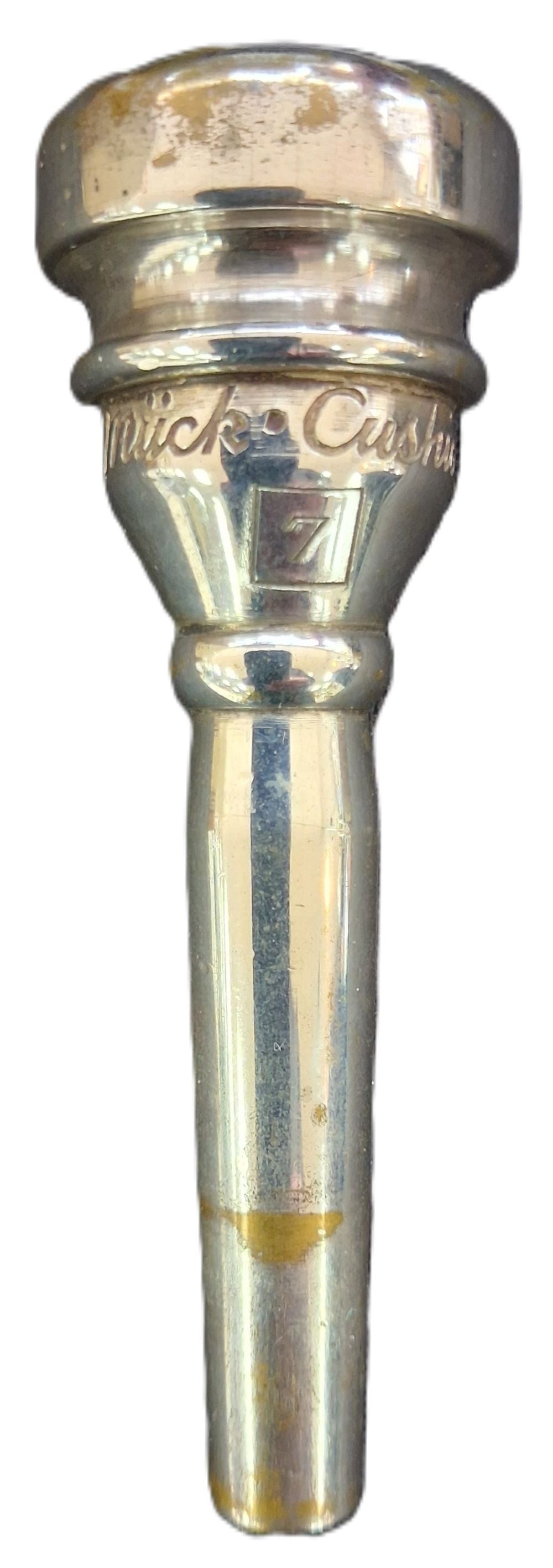 A silver metallic trumpet mouthpiece with engraved text reading 'Rudy Muck' and a size marking of 7.
