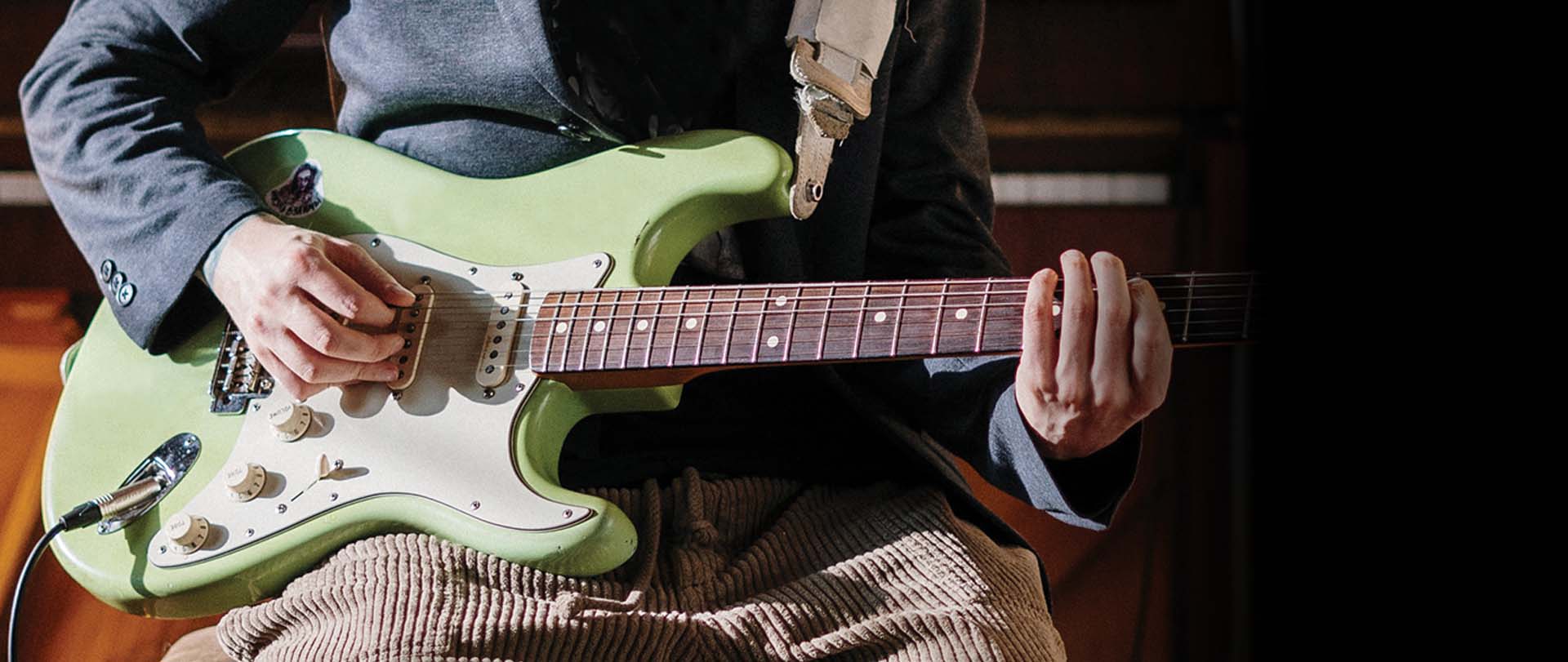 Person playing electric guitar during a lesson