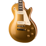 A gold-finish electric guitar with cream pickguard and hardware, shown from a side angle